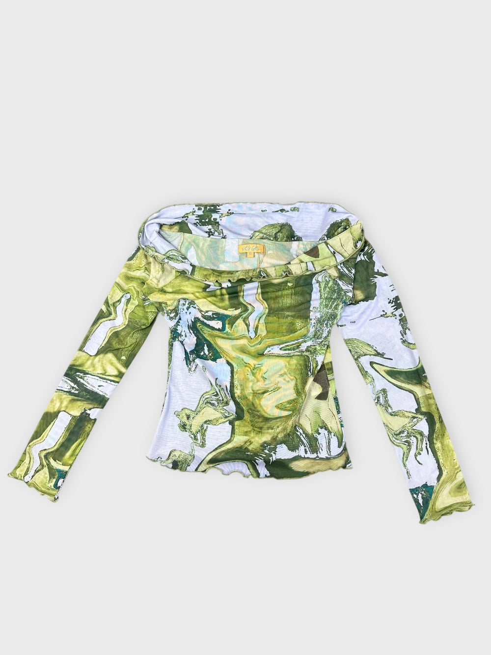 Abstract print long sleeve top in green with a frayed hem front view.