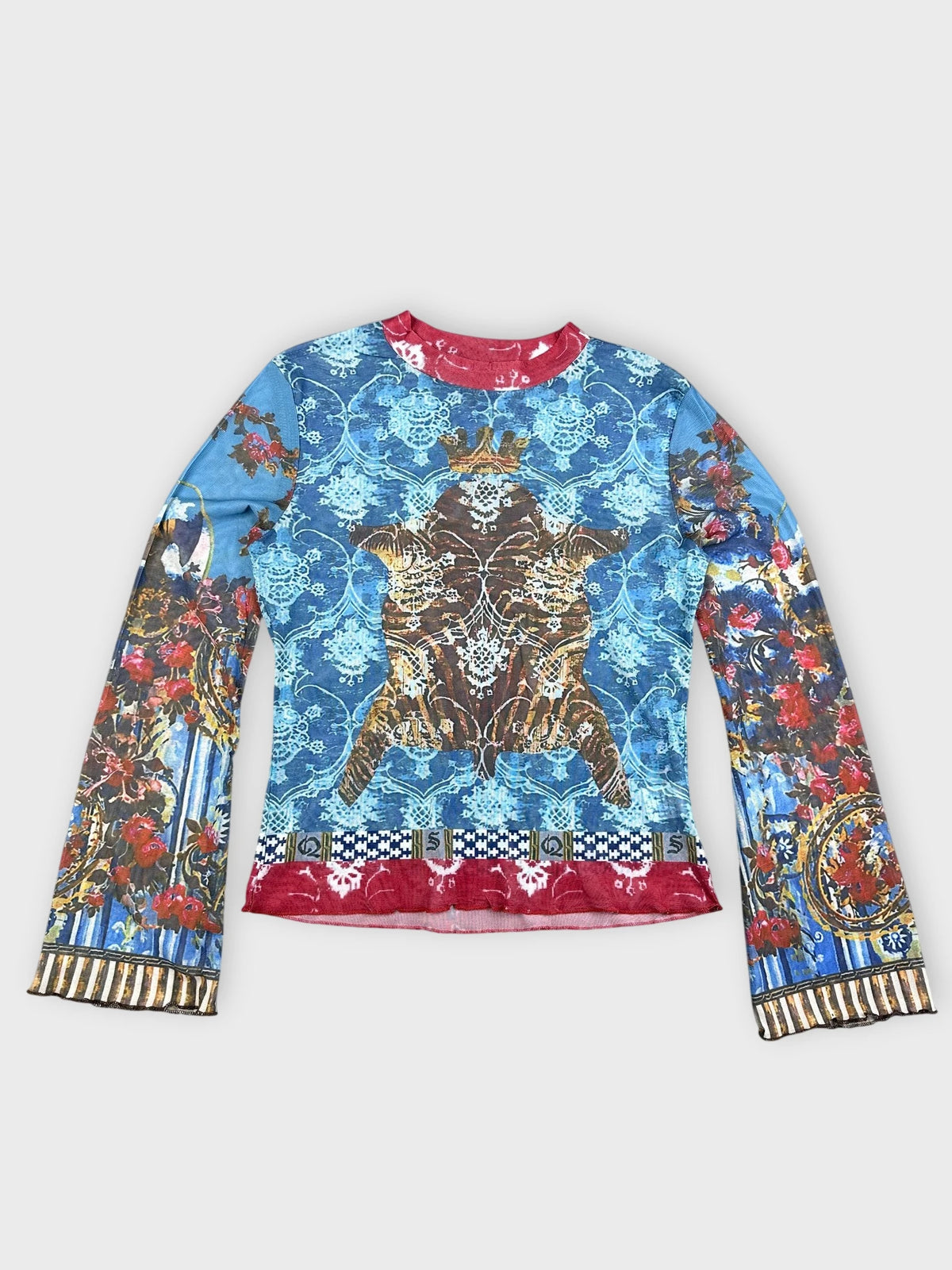 Detail view of a long-sleeve mesh top in blue with baroque print.