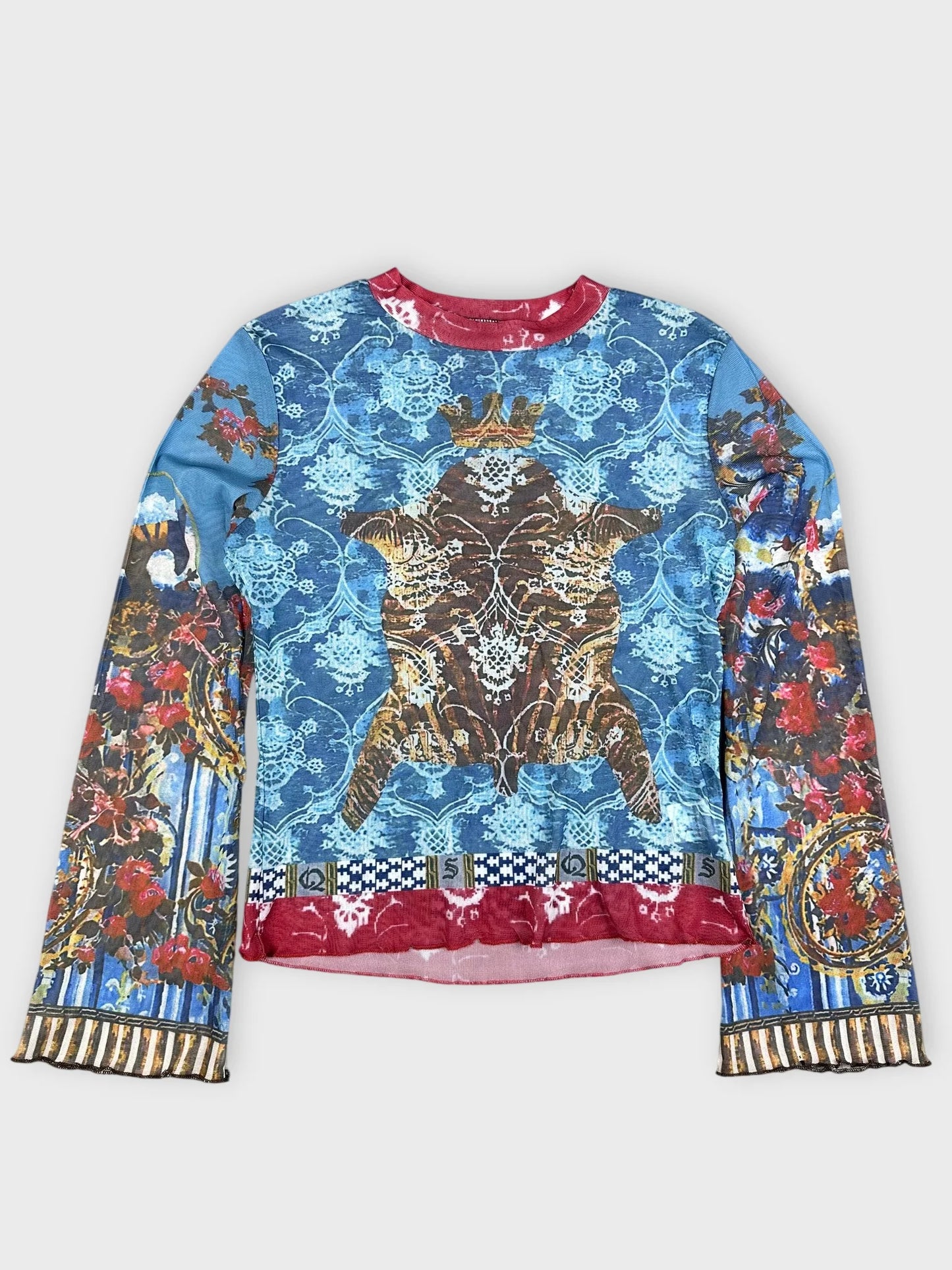 Detail view of a blue mesh top featuring baroque print and red trim.