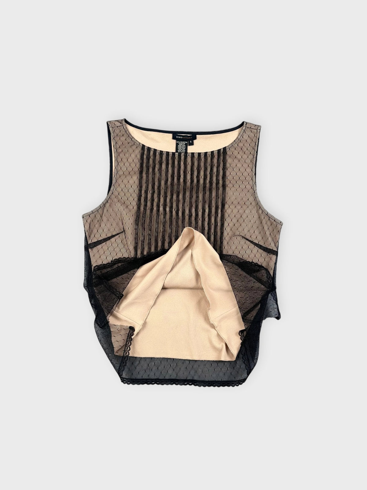 Detail view of a sleeveless black mesh top with pleated pattern.