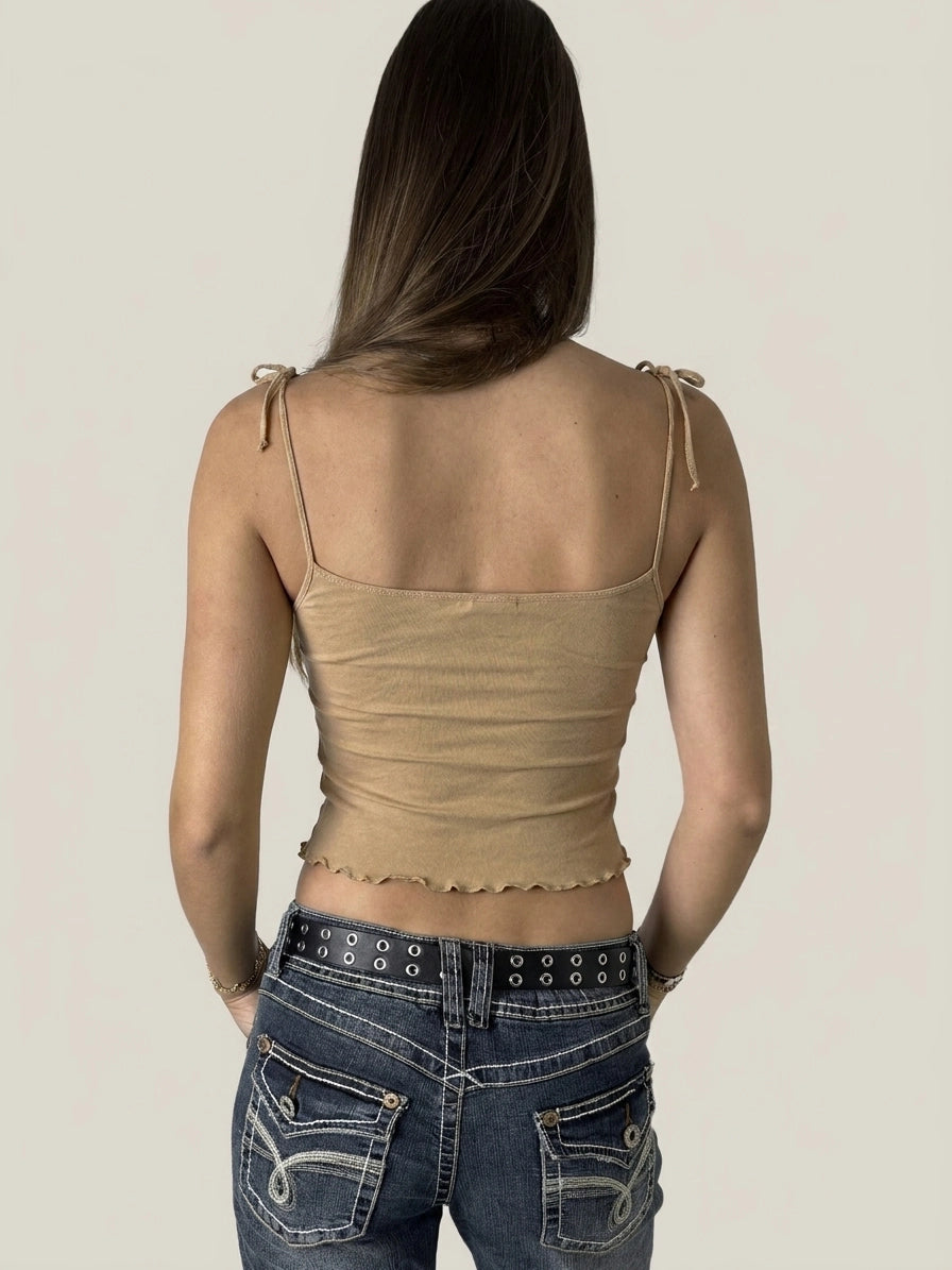 Back view of a beige ruffled crop top with playful edges.