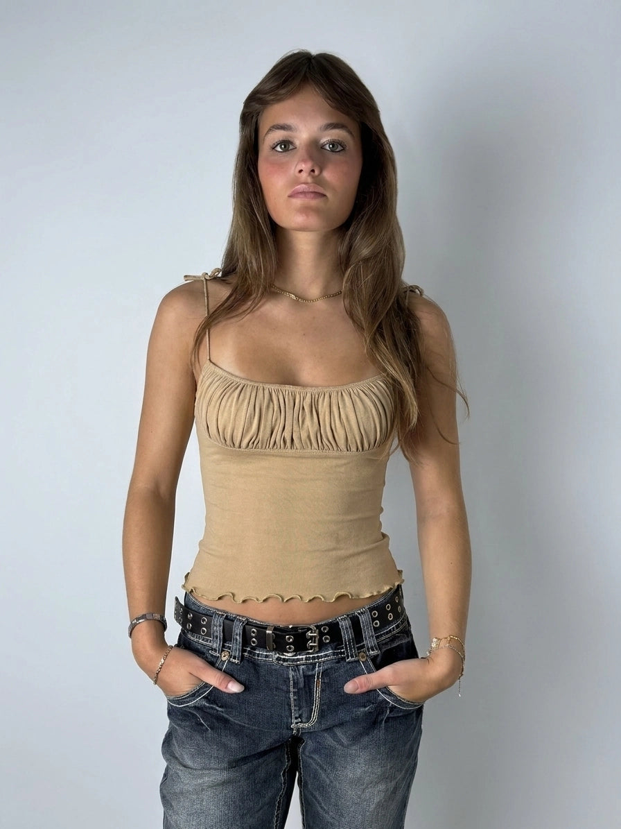 Beige ruffled crop top with playful edges, front view, featuring a gathered texture.