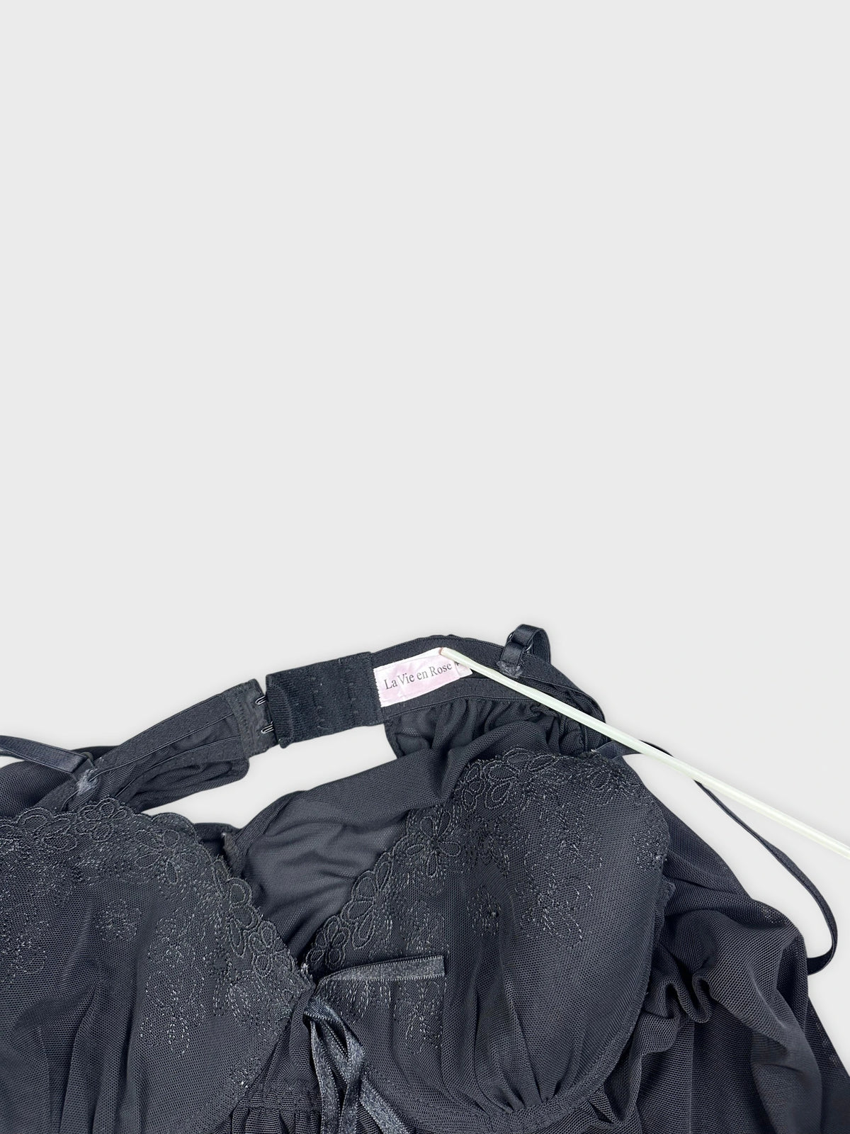 Black camisole with lace detail view showing floral embroidery and adjustable straps