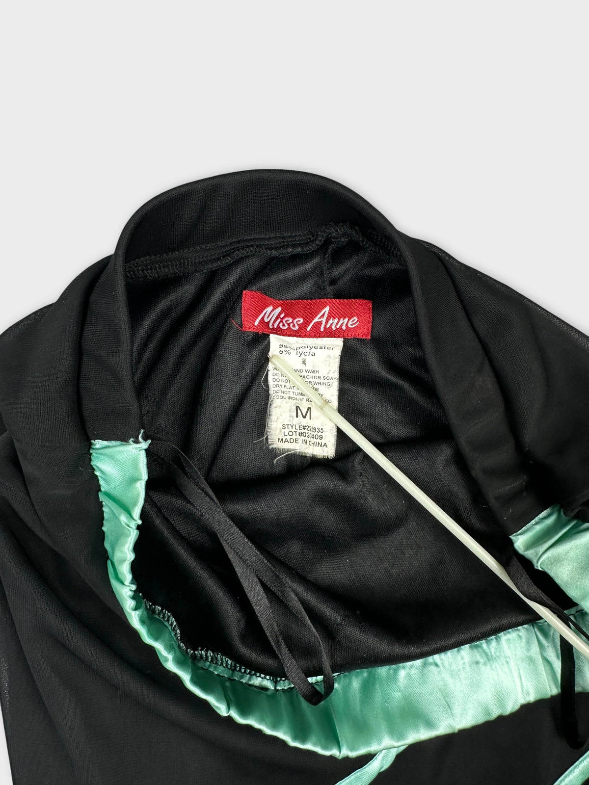 Detail view of a black skirt with aqua accents and satin trim.