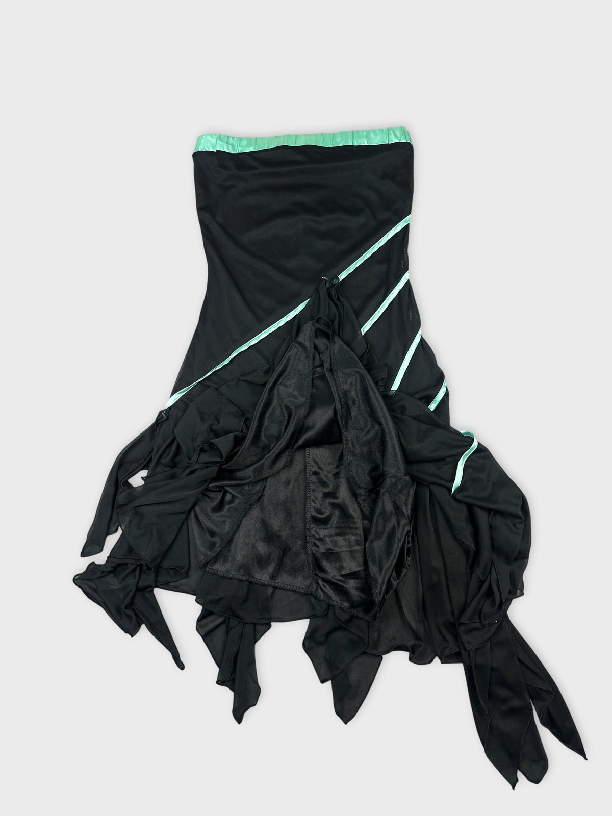 Detail view of a black flowing skirt with aqua accents and asymmetrical shape.