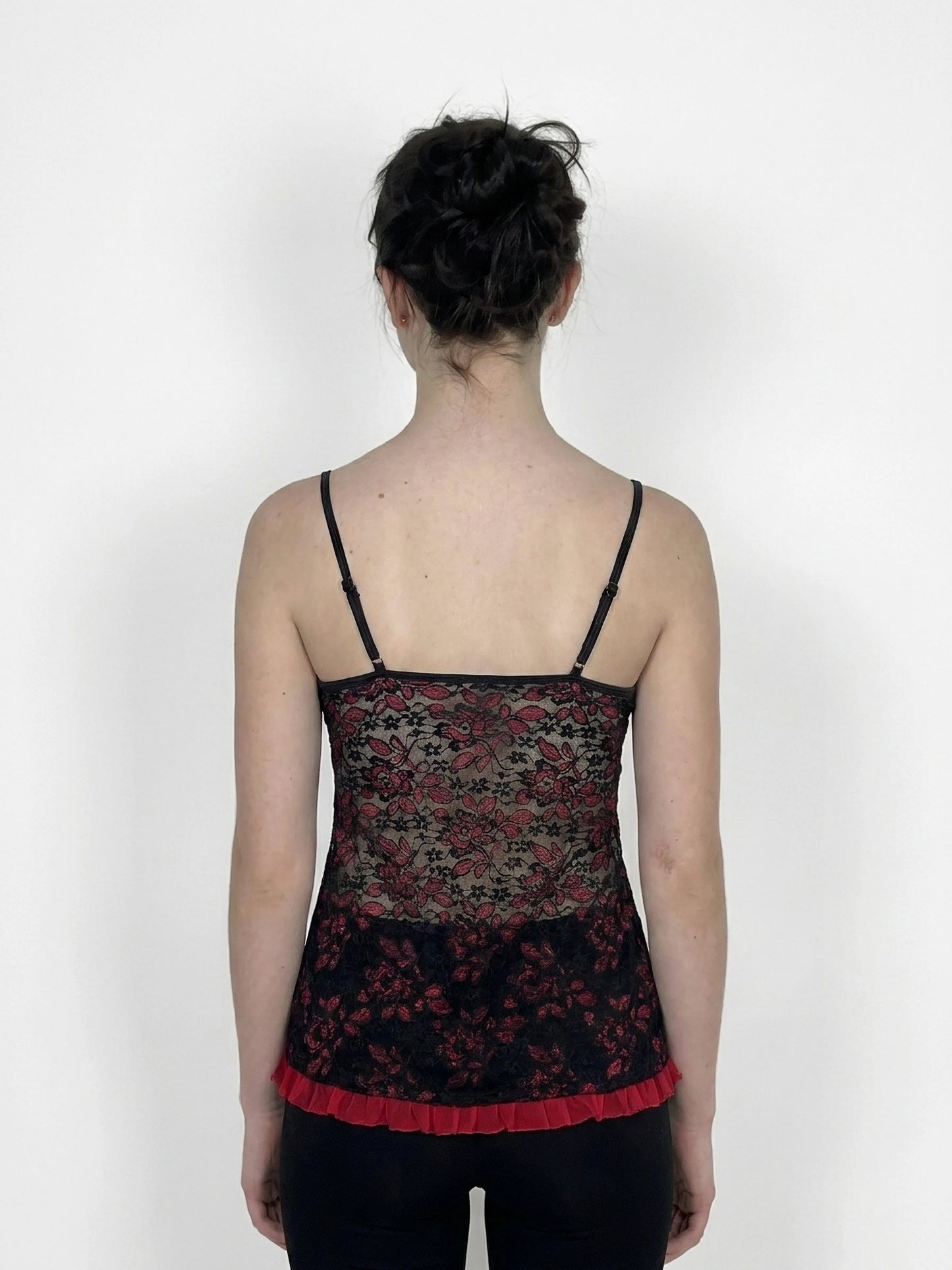 Back view of black lace camisole with red trim and floral pattern.