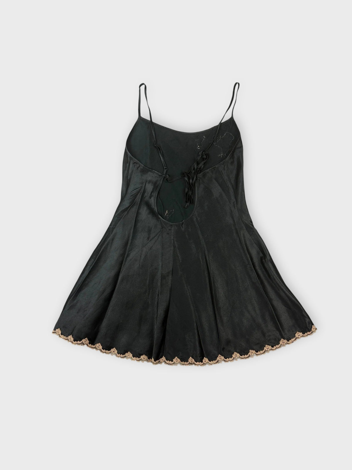 Back view of a black lace trimmed cami top with a flared hem.