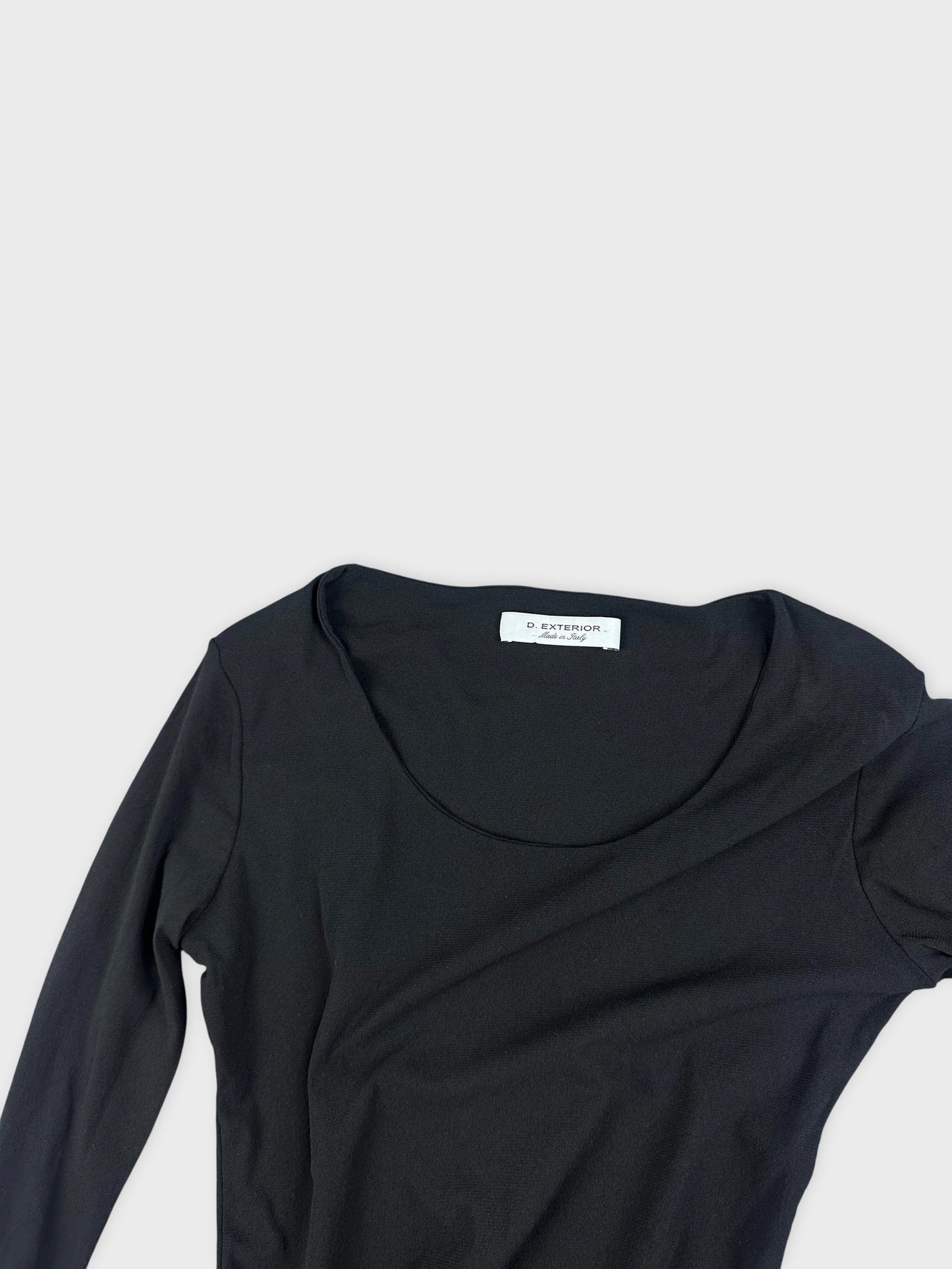 Detail view of a black long sleeve knit dress with a scoop neckline.