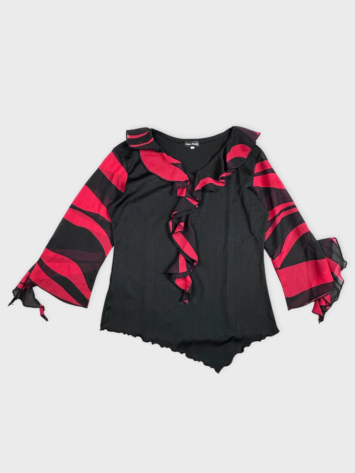 Detail view of a black top with red stripes and ruffled neckline.