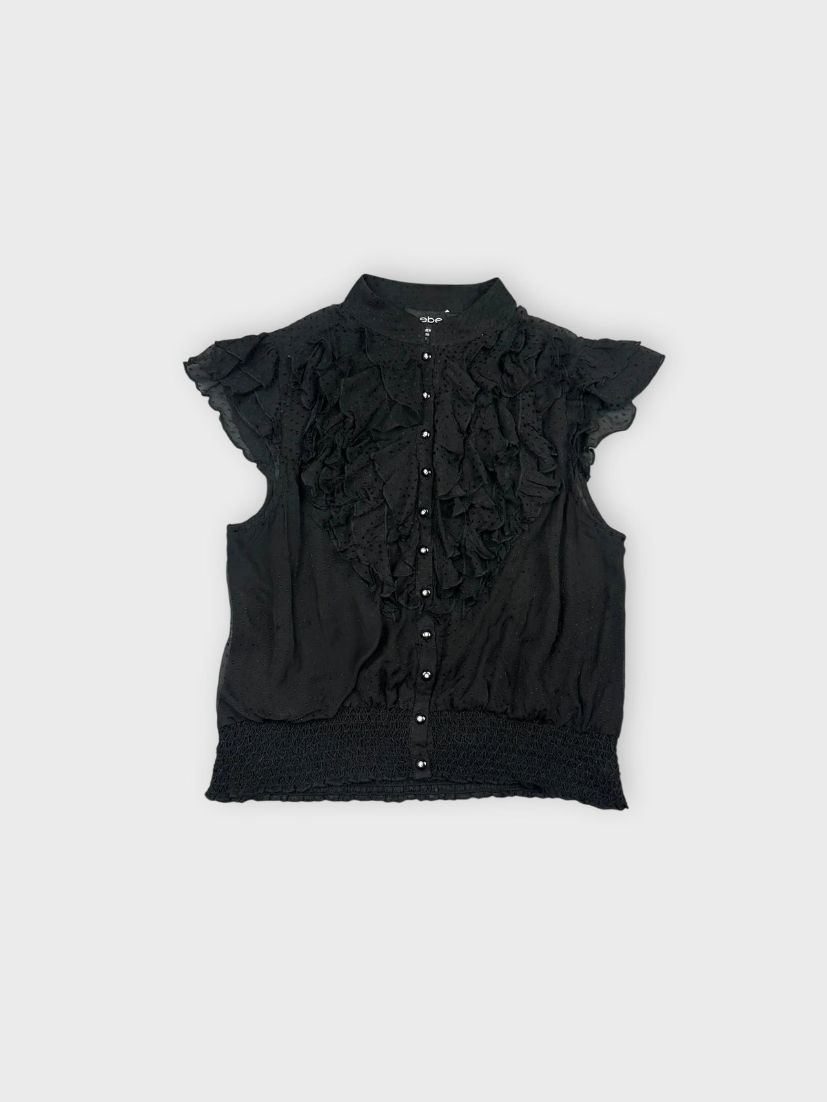 Front view of a black ruffled blouse with button details.