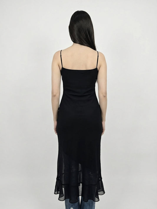 Back view of a black sheer maxi dress with a ruffle hem.