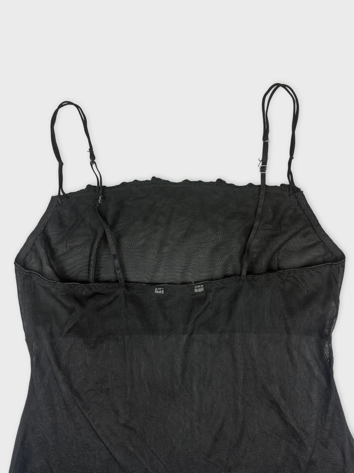 Back view of a black sheer slip dress with spaghetti straps.