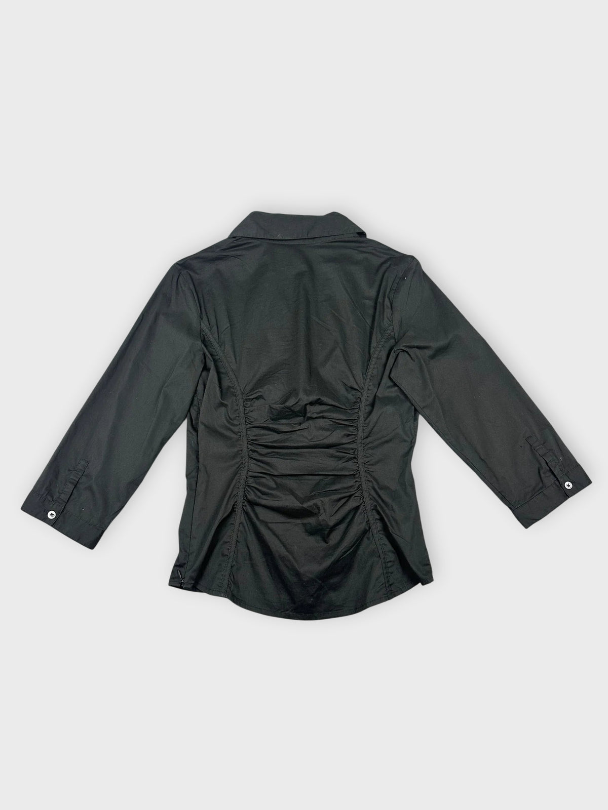 Black short sleeve shirt with ruching back view showcasing smooth silhouette.