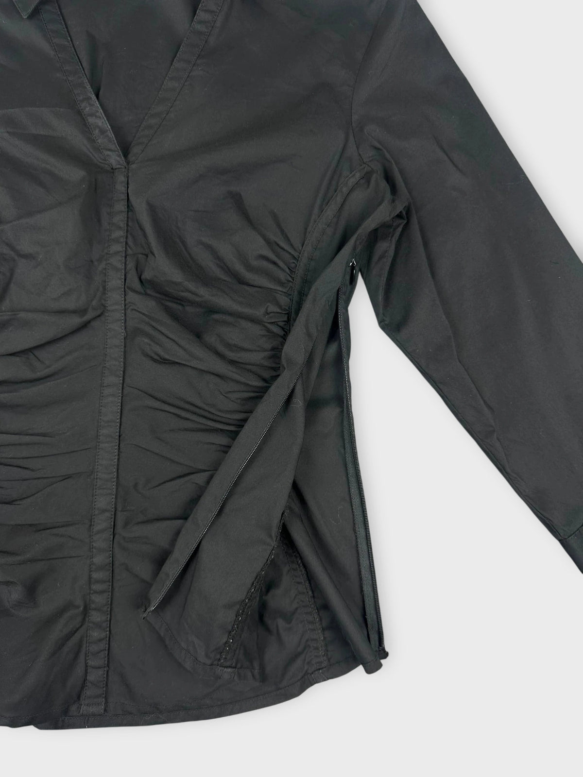 Detail view of a black short sleeve shirt with side ruching.