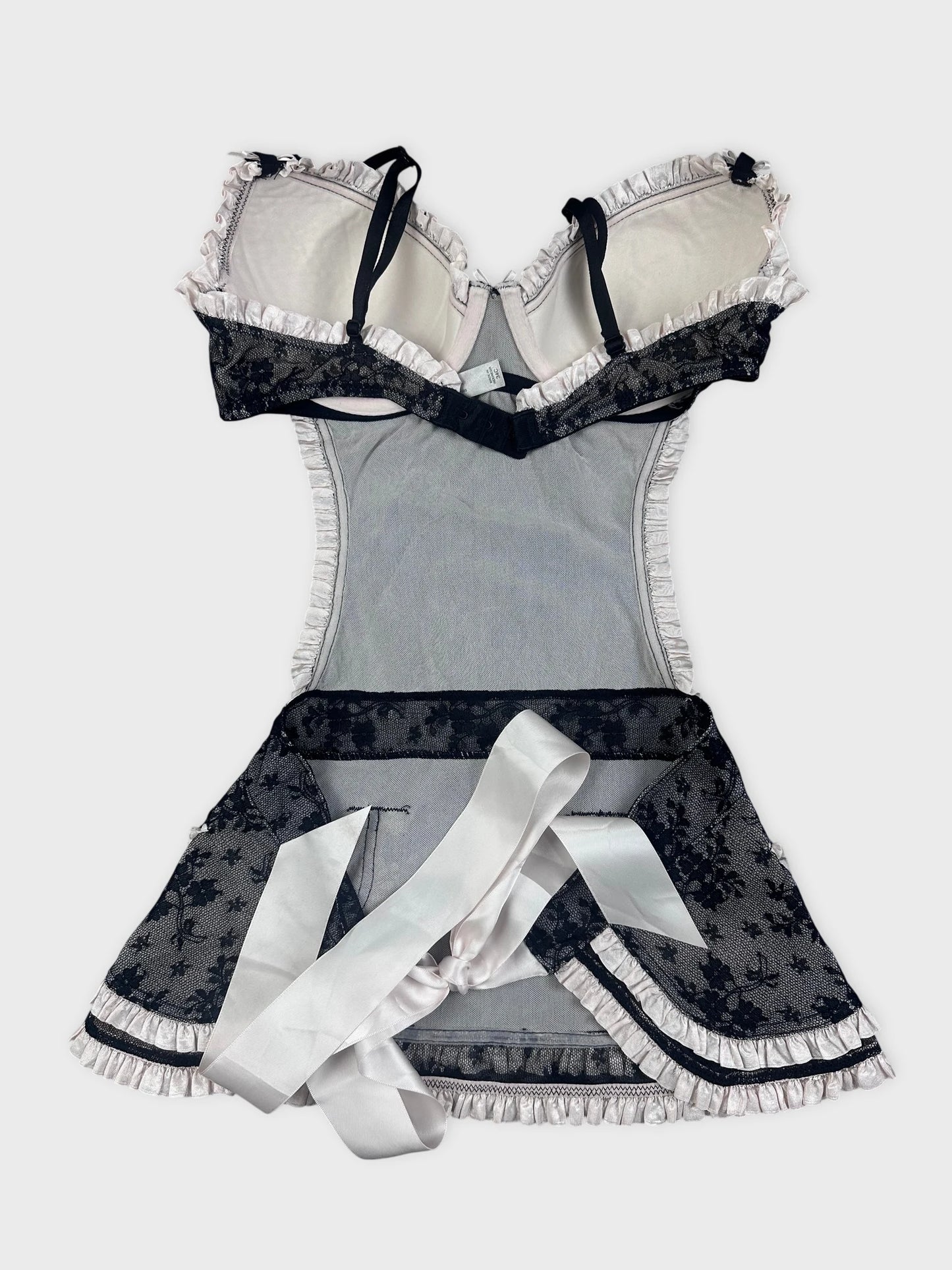 Back view of black lace top with ruffled trim and satin ribbon detail.