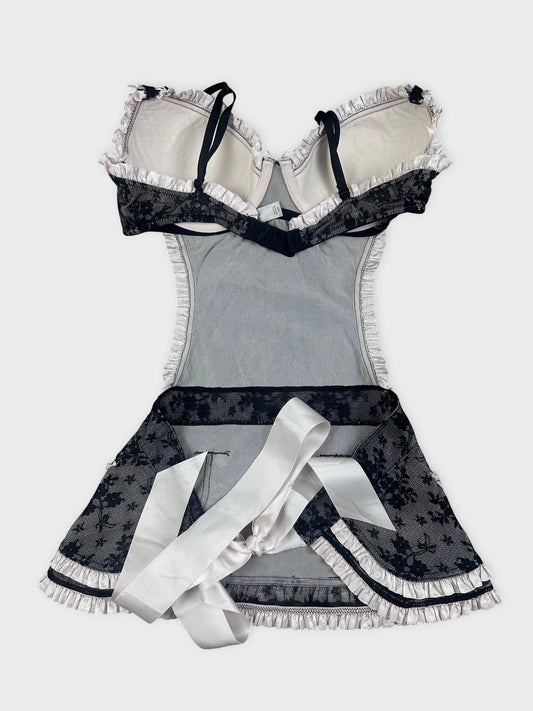 Back view of black lace top with ruffled trim and satin ribbon detail.