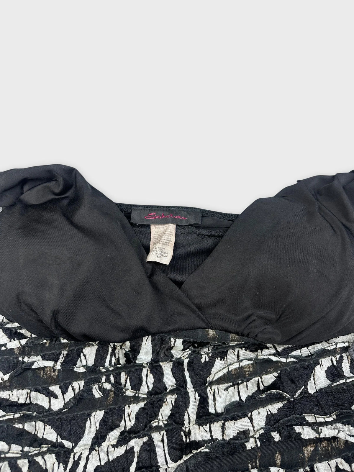 Detail view of black and white zebra striped mini dress neckline and fabric texture.
