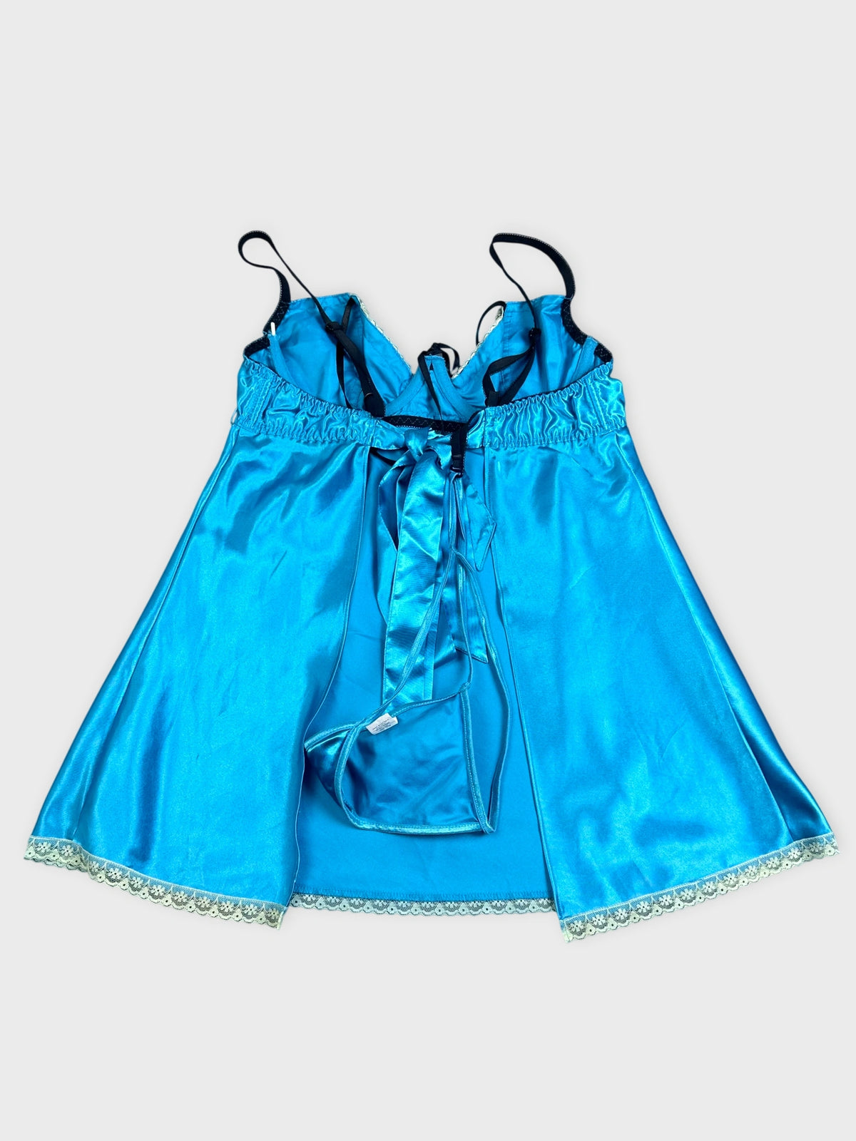 Detail view of a blue satin baby doll dress with lace trim.