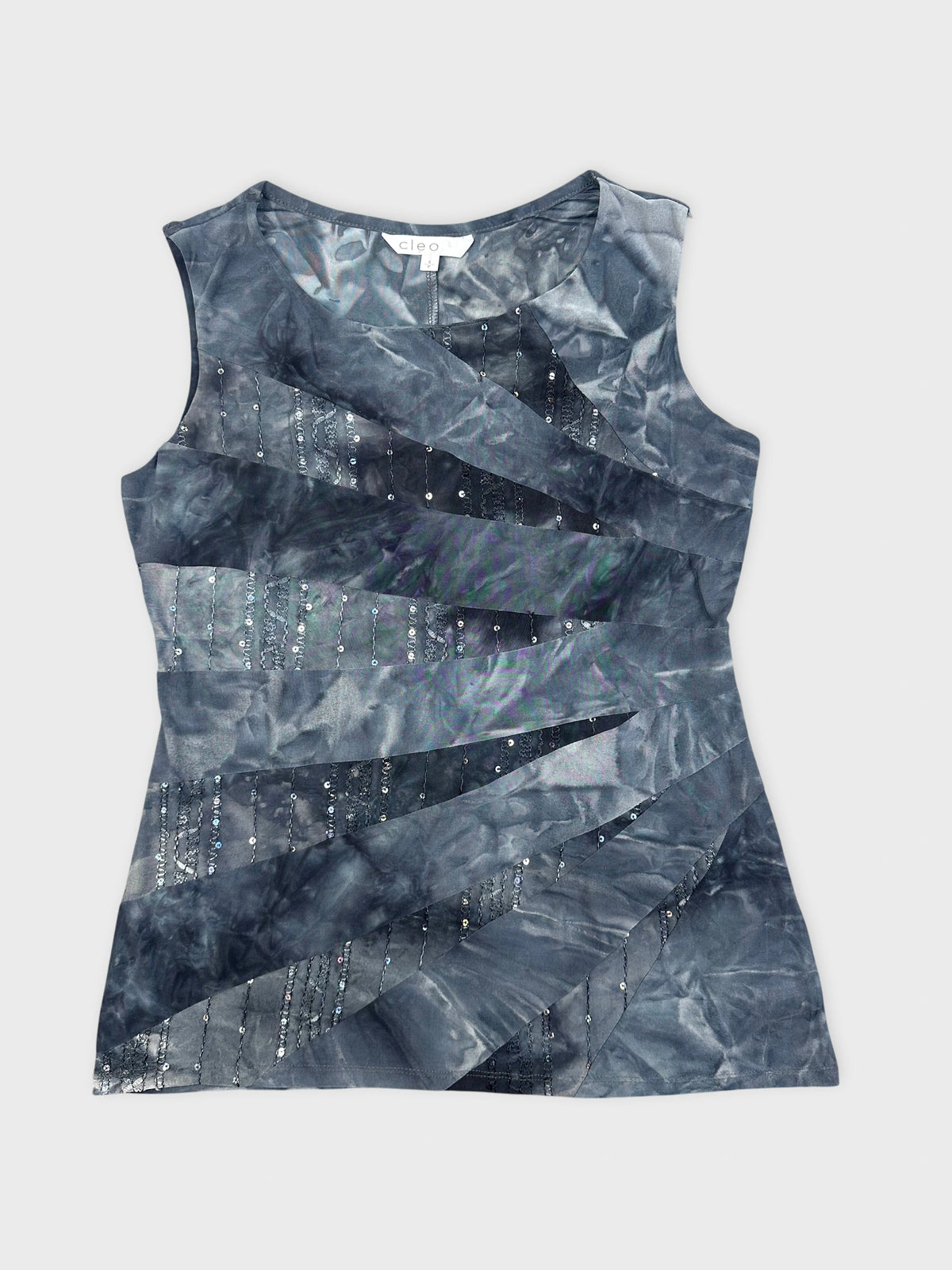 Detail view of blue sleeveless shirt with tie-dye pattern and sequined design.