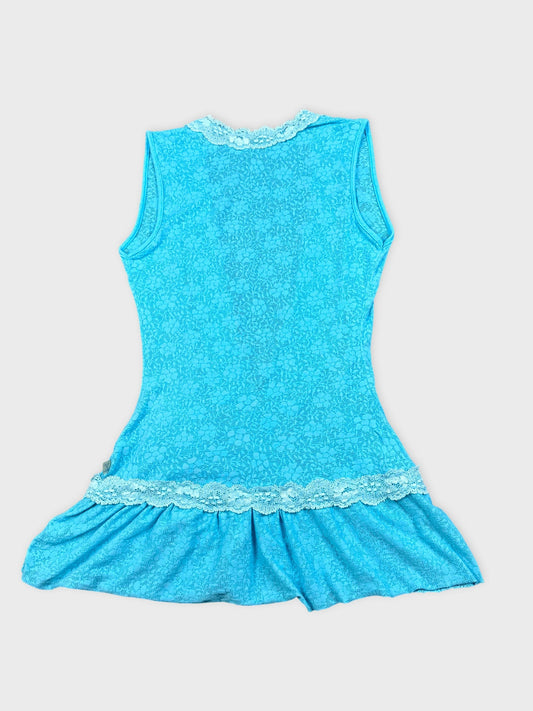Back view of a blue top featuring a lace trim and flared hem.