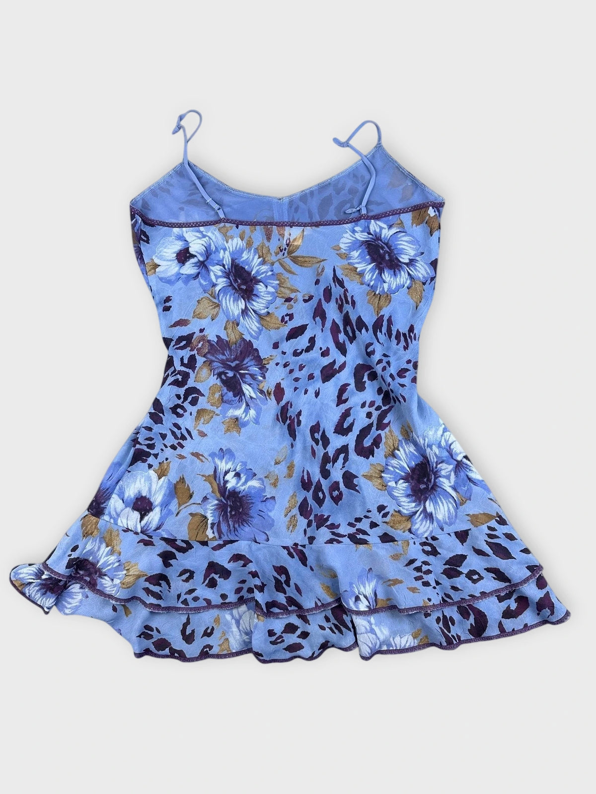 Back view of a blue floral ruffle dress featuring a ruffled hem