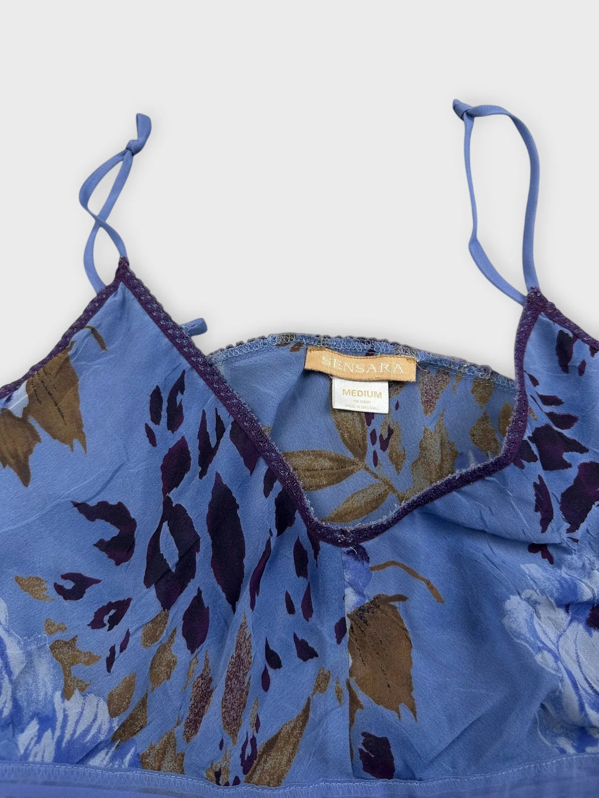 Detail view of blue floral ruffle dress with adjustable straps.