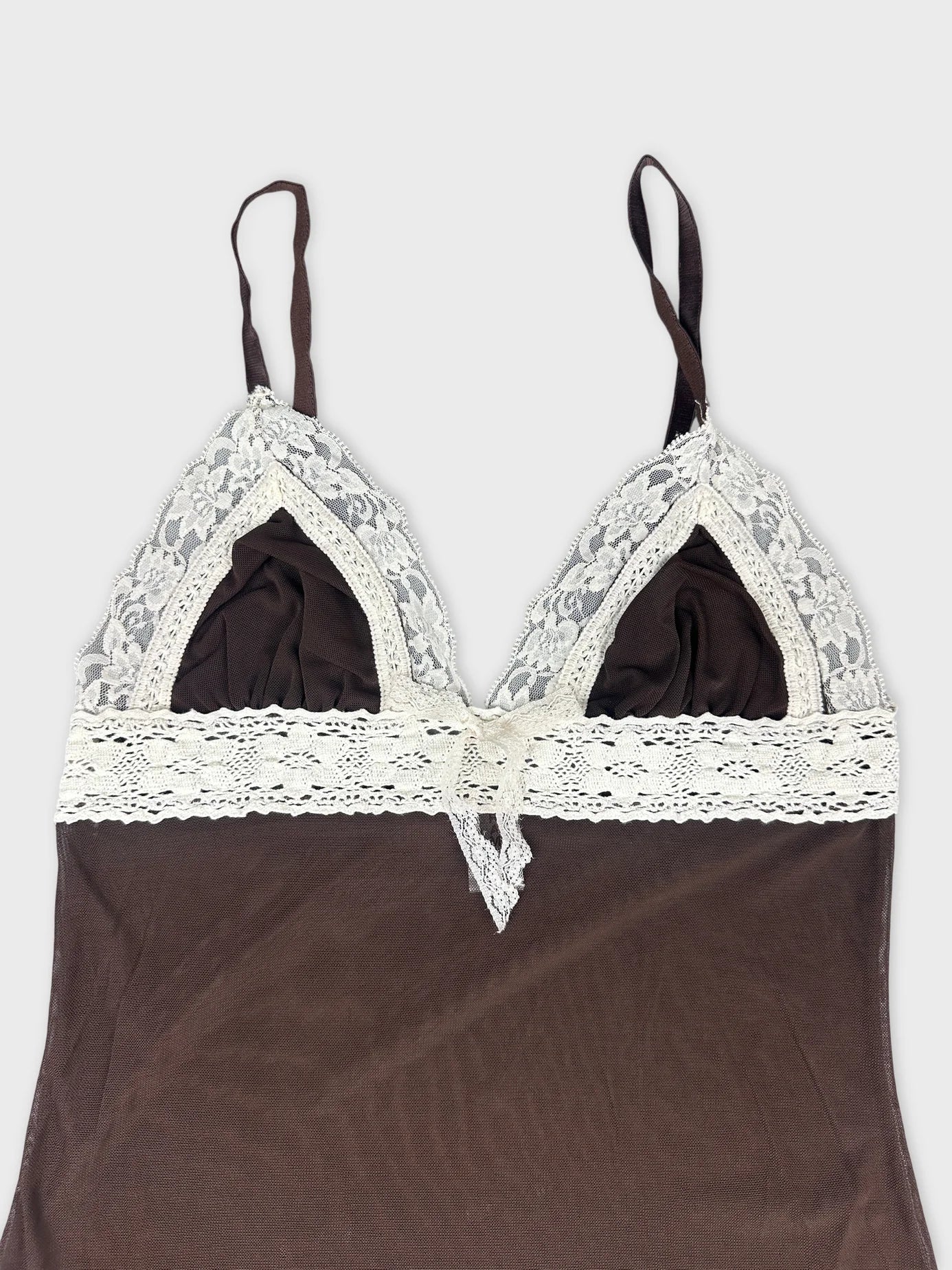 Detail view of brown mesh crop top with lace trim and adjustable straps.