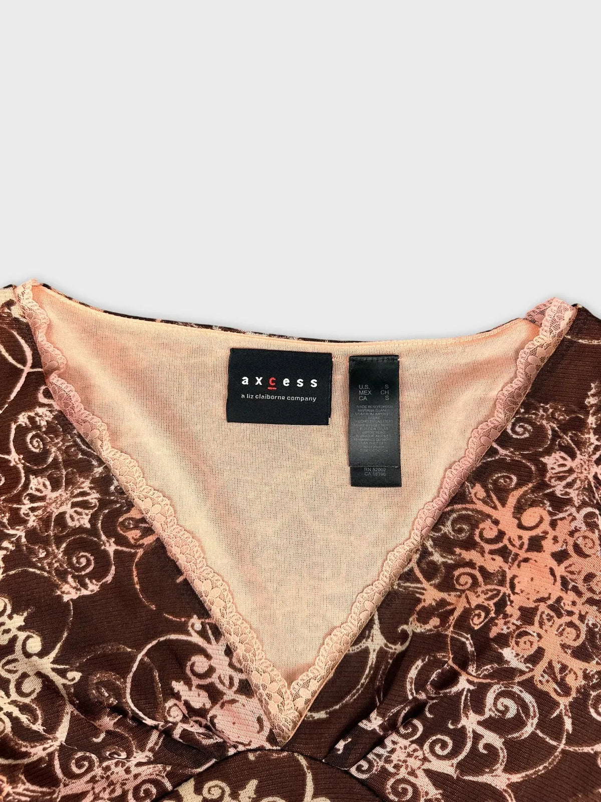 Detail view of brown sheer long sleeve top with floral print and lace trim