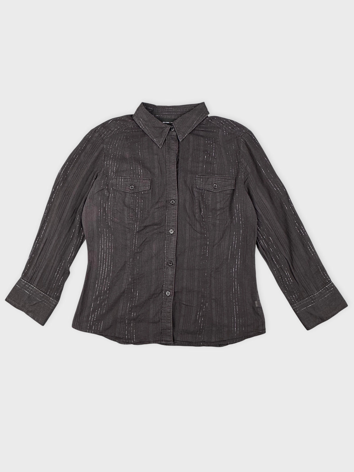 Detail view of a brown striped classic shirt featuring a button-down front.