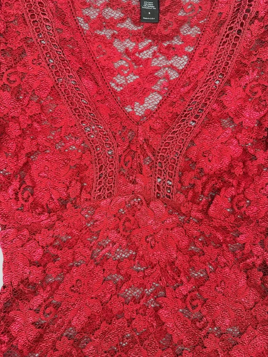 Detail view of a burgundy lace blouse featuring a V-neck and floral pattern.