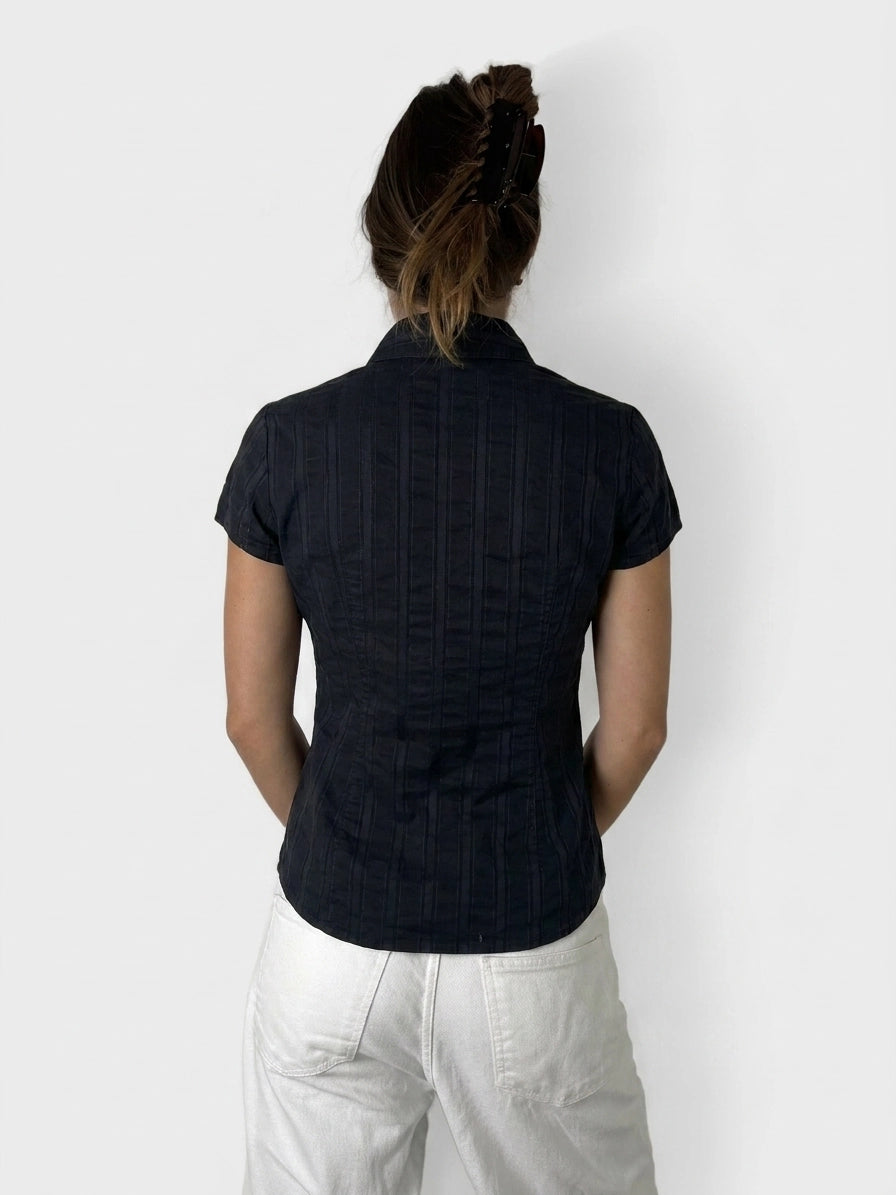 Back view of a black button-up shirt with subtle ribbed texture.
