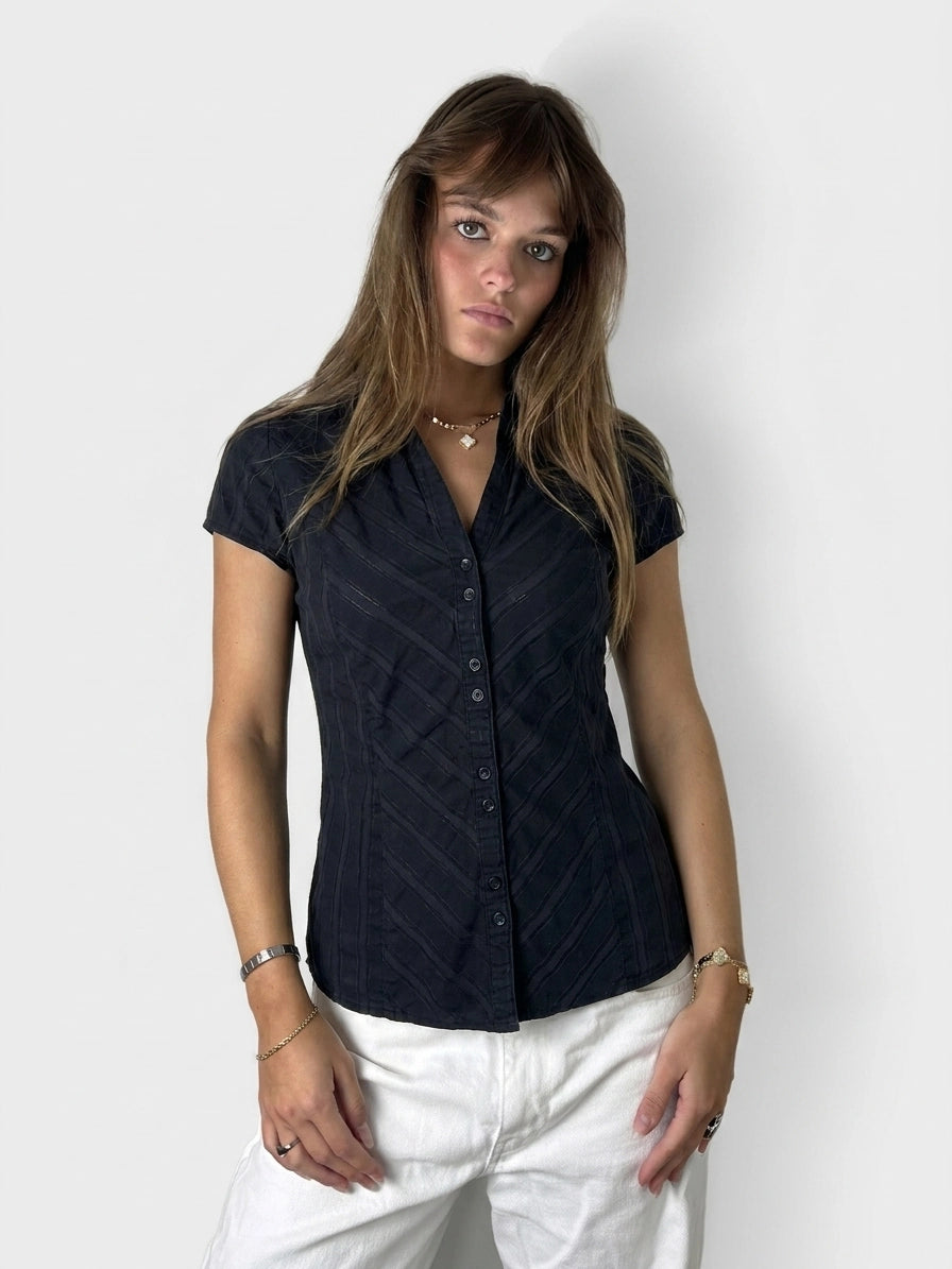 Chic black button-up shirt with subtle texture, front view.