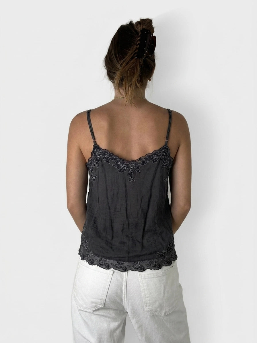 Back view of a black camisole featuring lace trim detail.