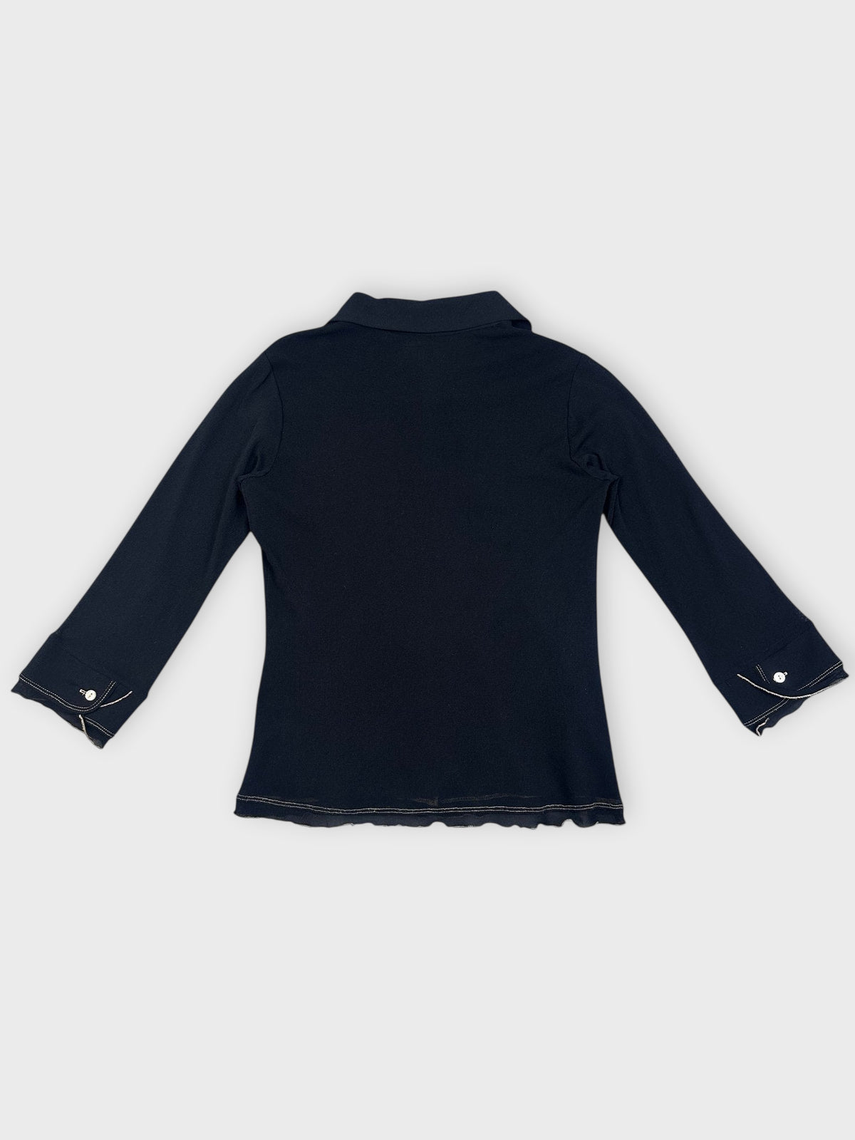 Back view of a black collared shirt with ruffled hem