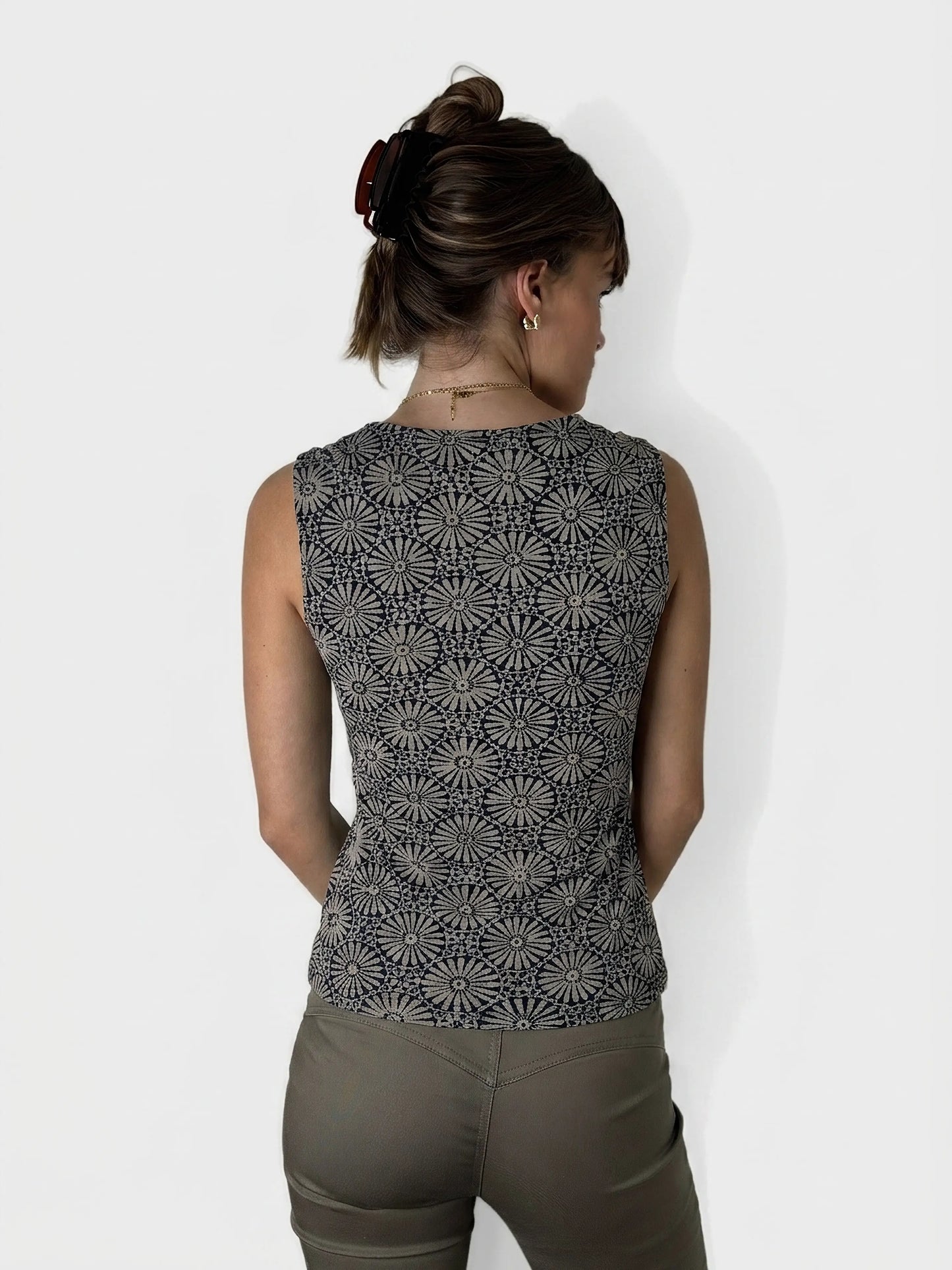 Back view of a black floral print tank top with a sleeveless design.