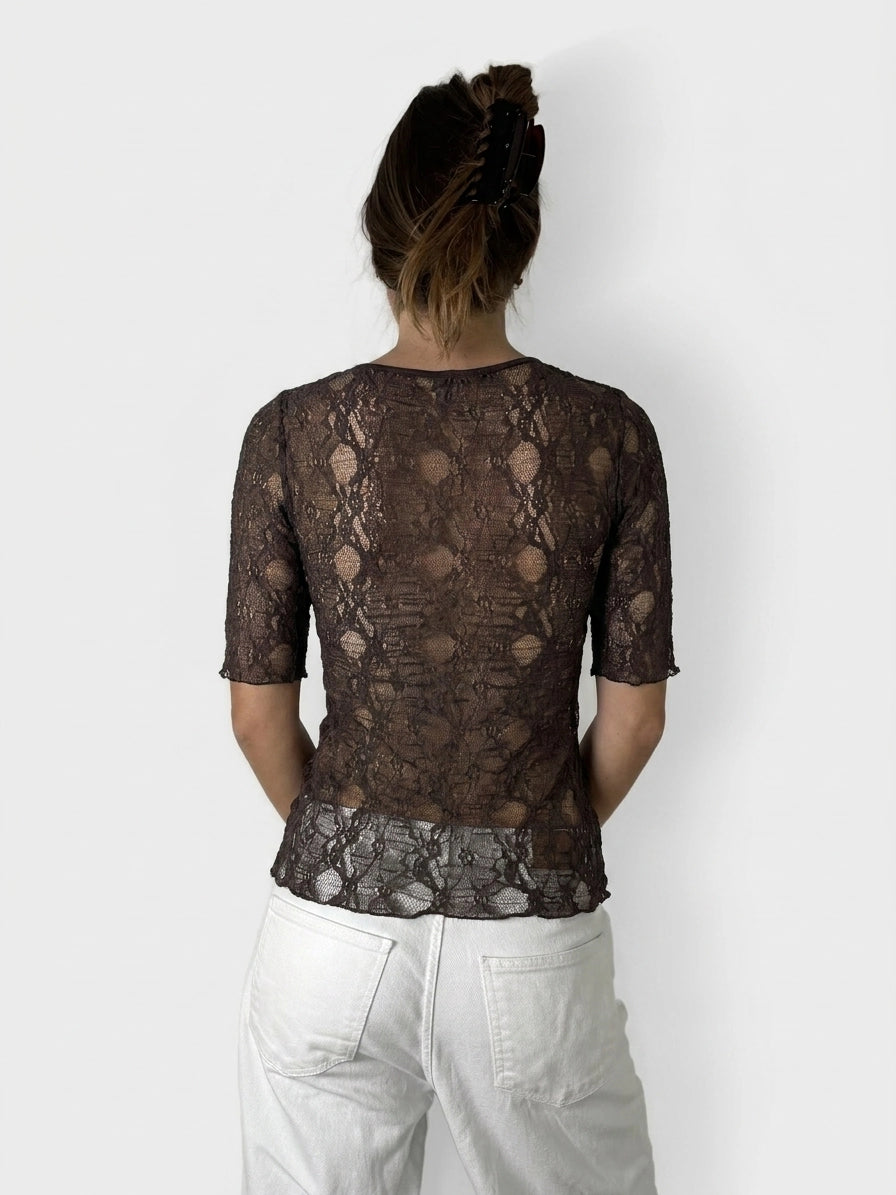 Back view of a black lace top featuring short sleeves and floral pattern.