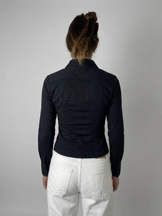 Back view of a chic black long sleeve button-up shirt with fitted shape.