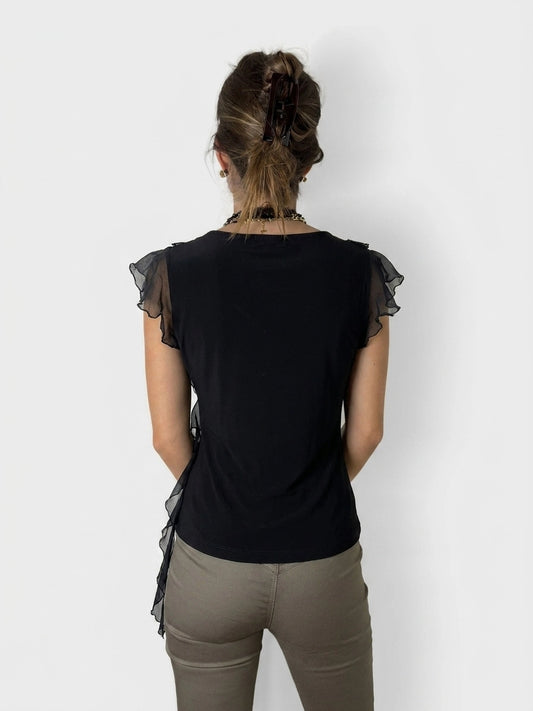 Back view of a black ruffle wrap top with sheer sleeves.