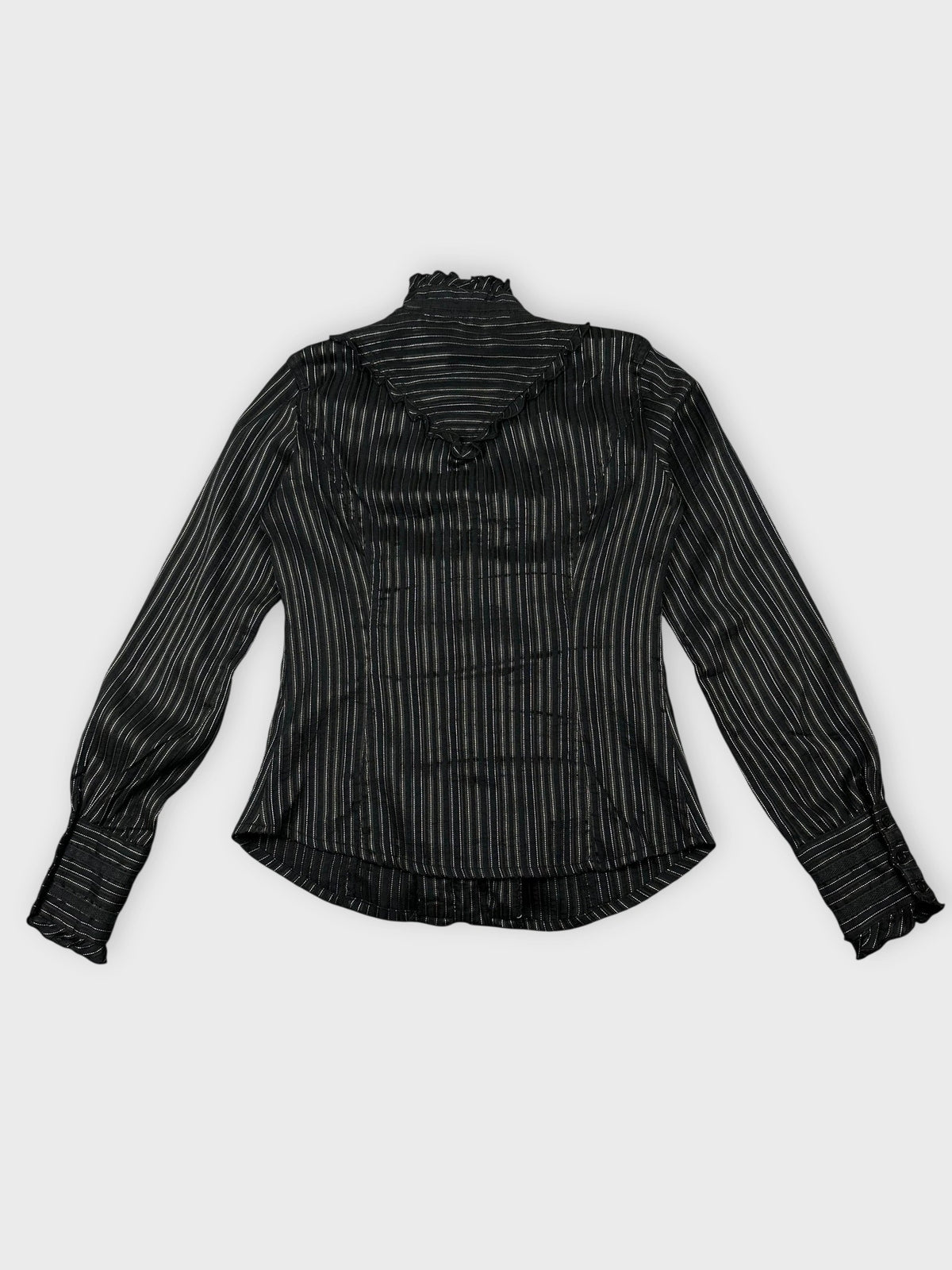 Back view of black striped blouse with ruffled hem detail.
