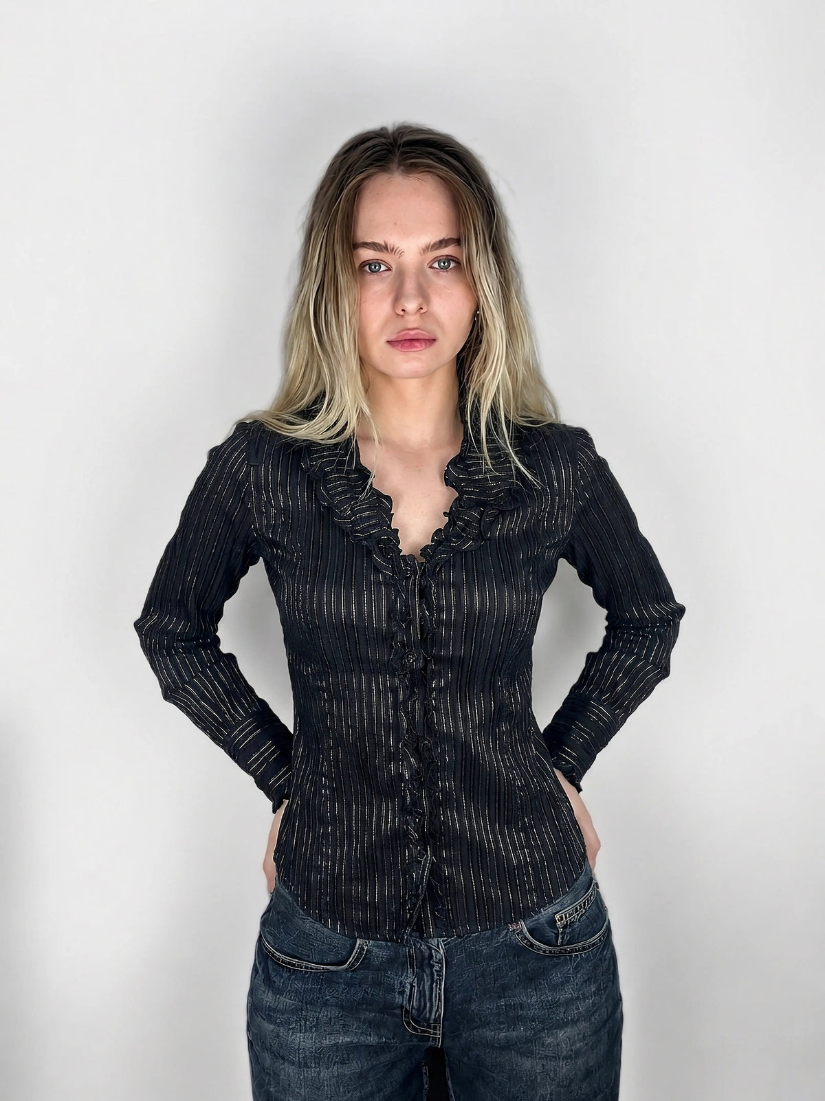 Chic black striped ruffled blouse with front view showing intricate ruffle detail.