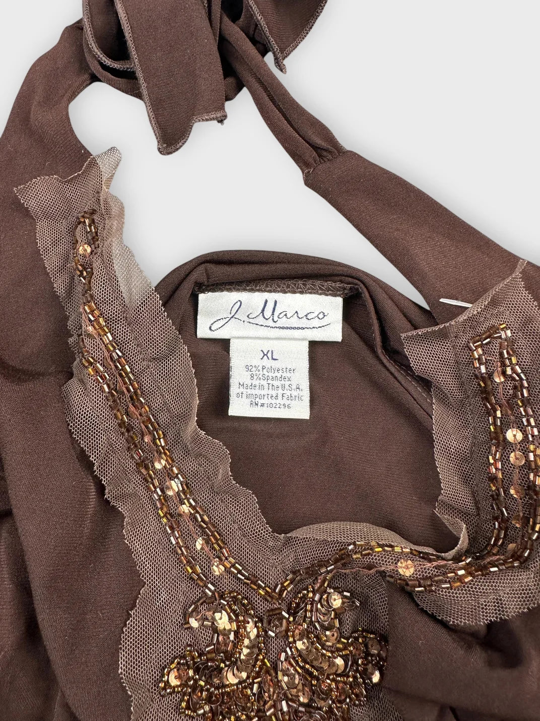 detail view of brown halter top featuring embellished trim and intricate beadwork