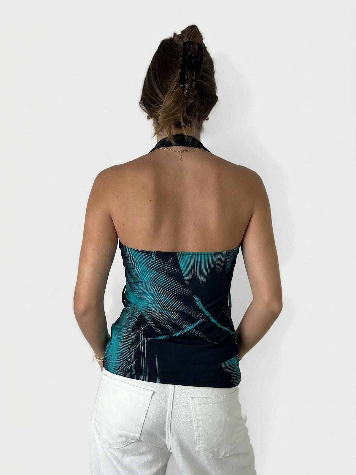 Back view of a cowl neck top in navy with edgy teal patterns.