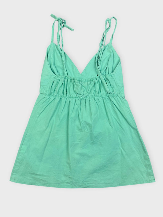 Back view of a mint green mini dress with adjustable straps and a V-neck design.