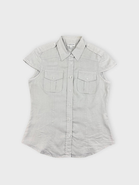 Front view of light beige button-up top with short sleeves and pocket detail.