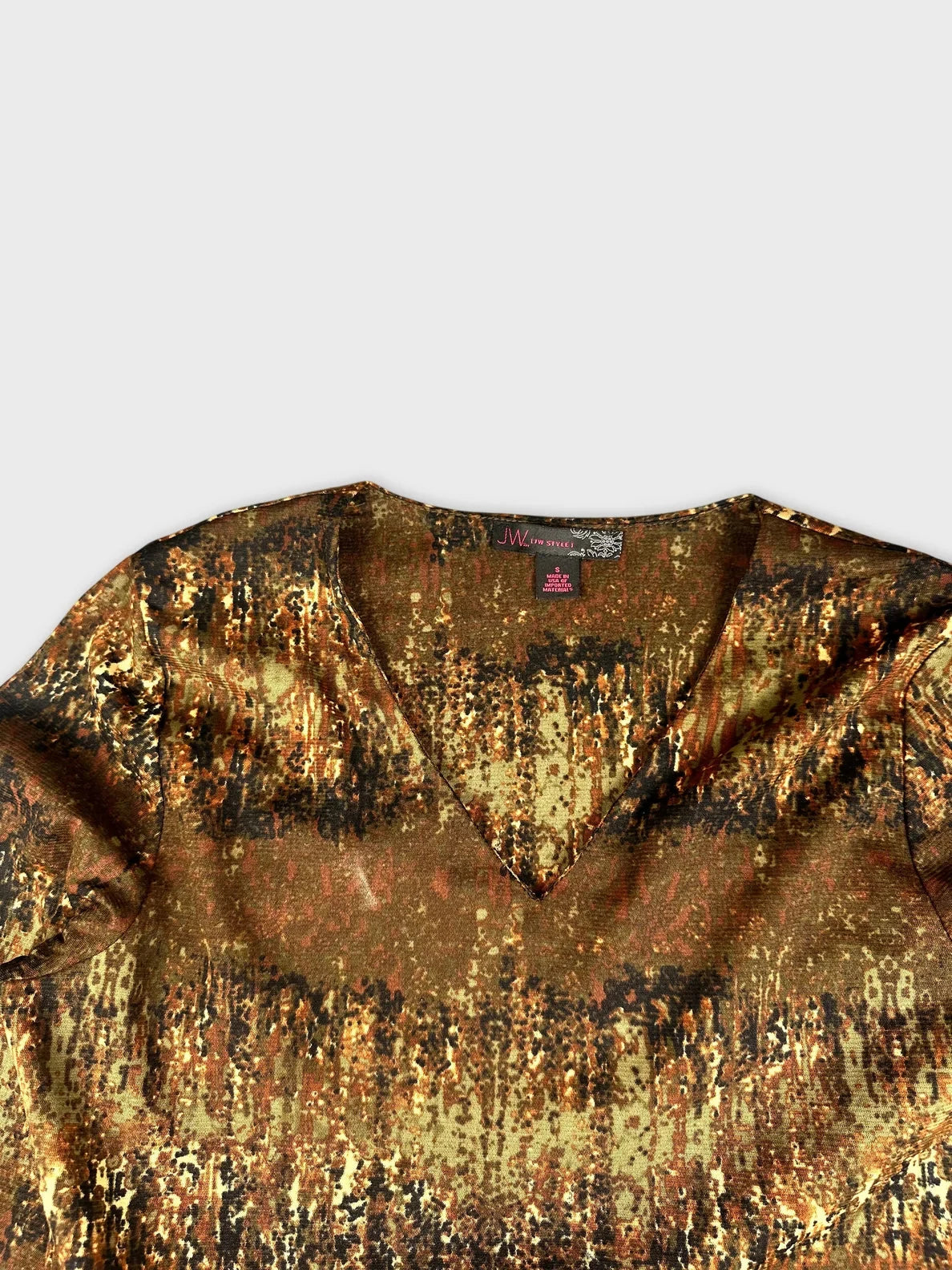 Detail view of long sleeve V-neck top in earthy tones with nature-inspired print.