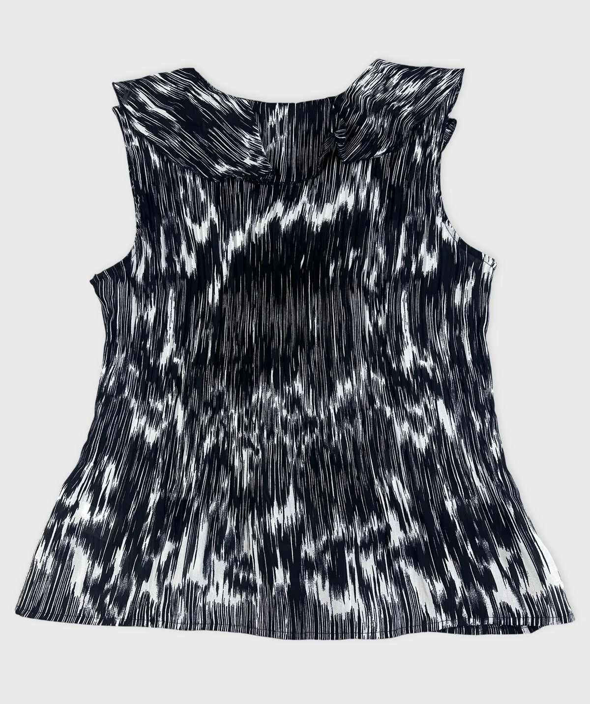 Back view of black and white plissé top with ruffled detail.
