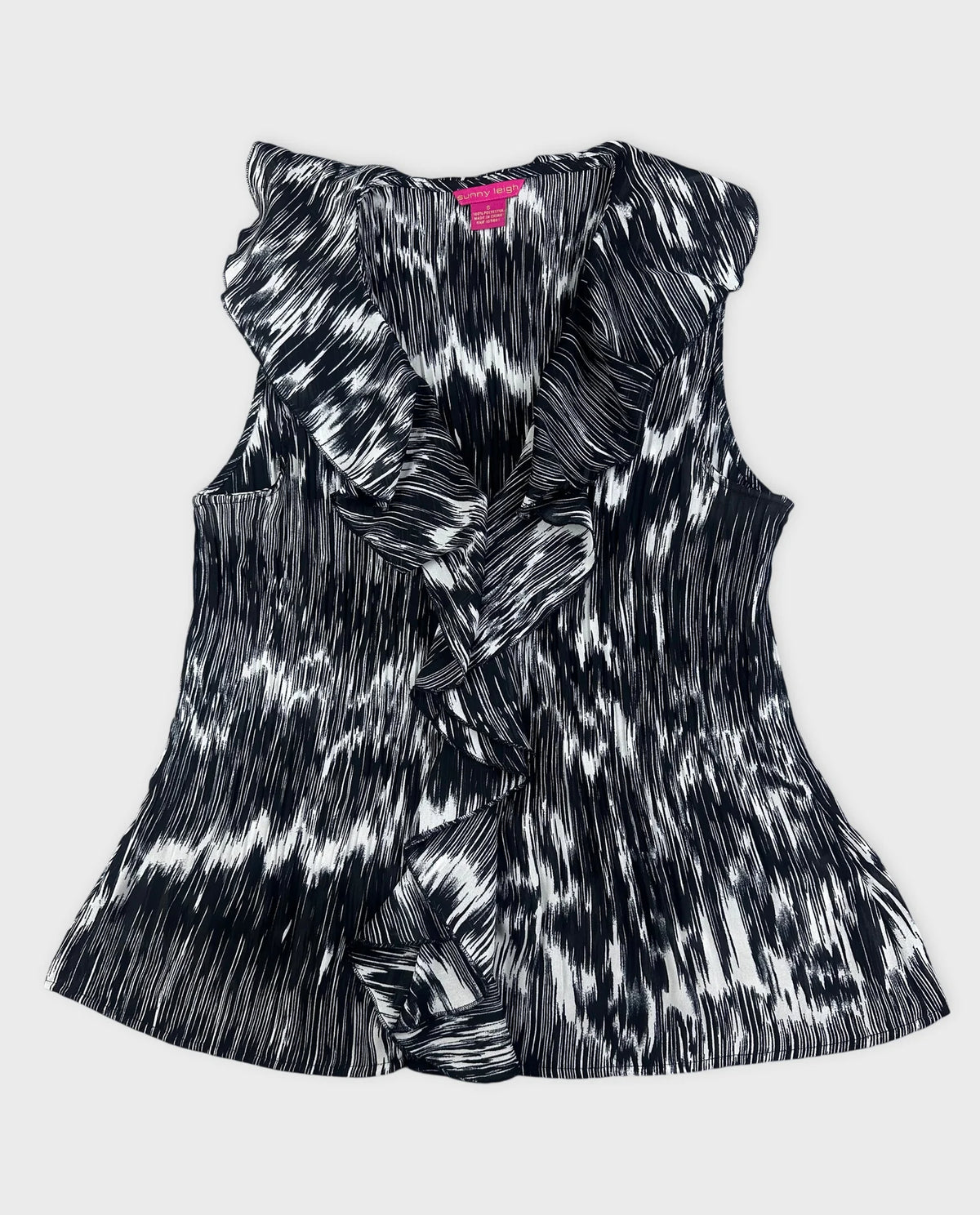 Chic plissé top in black and white with ruffled detail front view