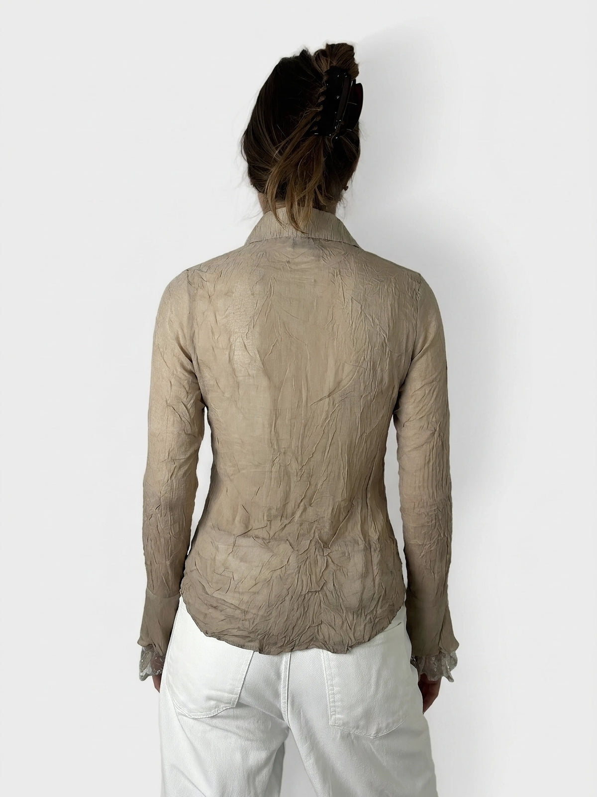 Back view of a beige long sleeve top featuring ruffled cuffs.
