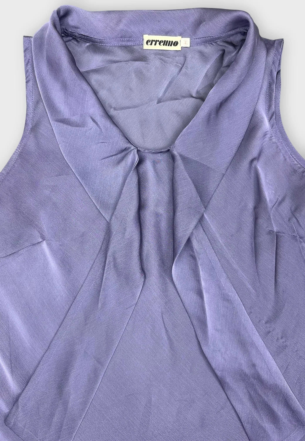 Detail view of a chic sheer purple top featuring draped design.