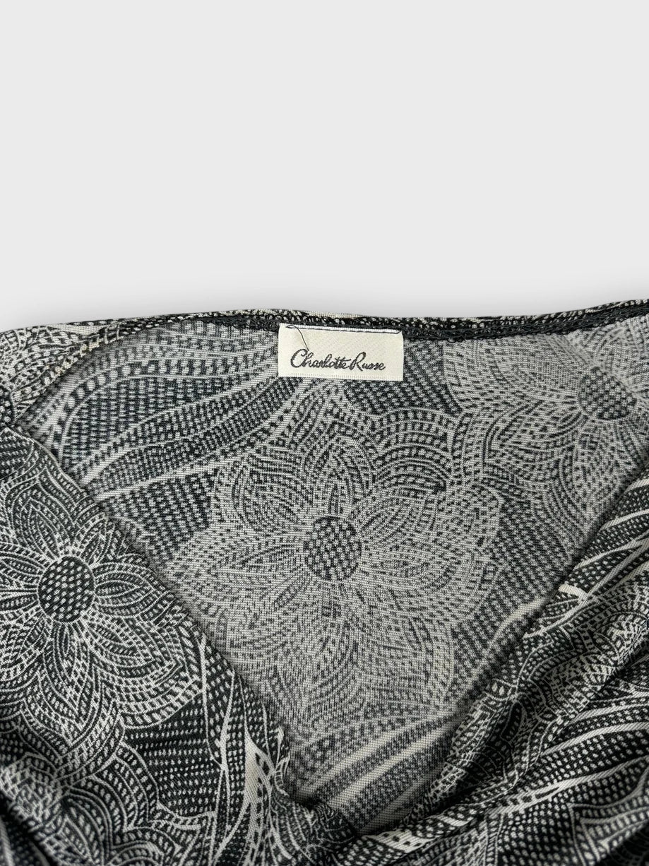 Detail view of a short sleeve gray top featuring a floral print.